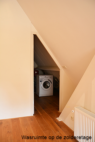 de wasruimte op de zolder etage van het appartement te Laren